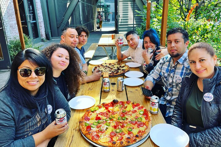 Group of people eating pizza on the portland pizza tour.